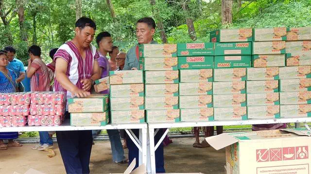 New Heights Ministry Evangelist Tawi assisting Jung in distributing food to the Mae Po villagers.