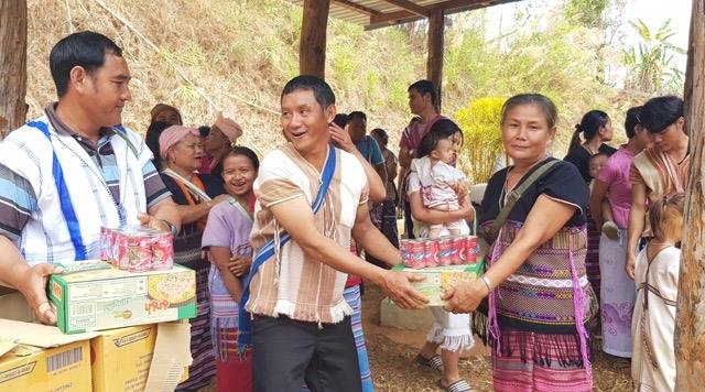 NHM evangelists Tawi and Sukchai handing out food items to Mae Po villagers 